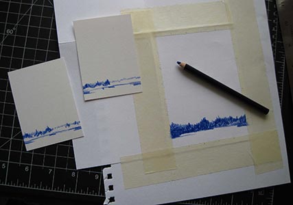 A dark blue pencil crayon sits on top of drawing paper.