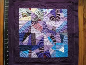 A patchwork sampler, with many curved quilted lines.